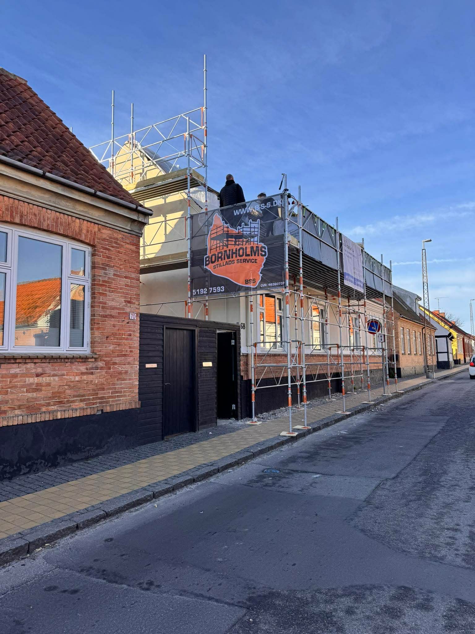 Facadestillads opsat på husfacade i Rønne med BSS-banner — Bornholms Stillads Service